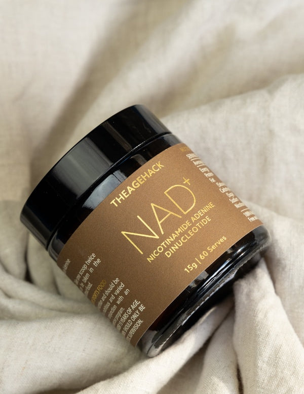 The Age Hack NAD powder styled on soft fabric