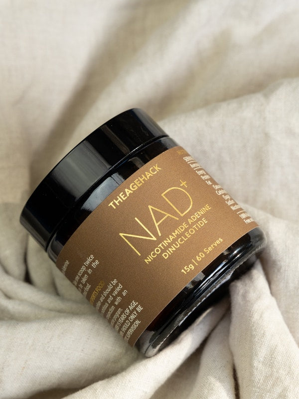 The Age Hack NAD powder styled on soft fabric