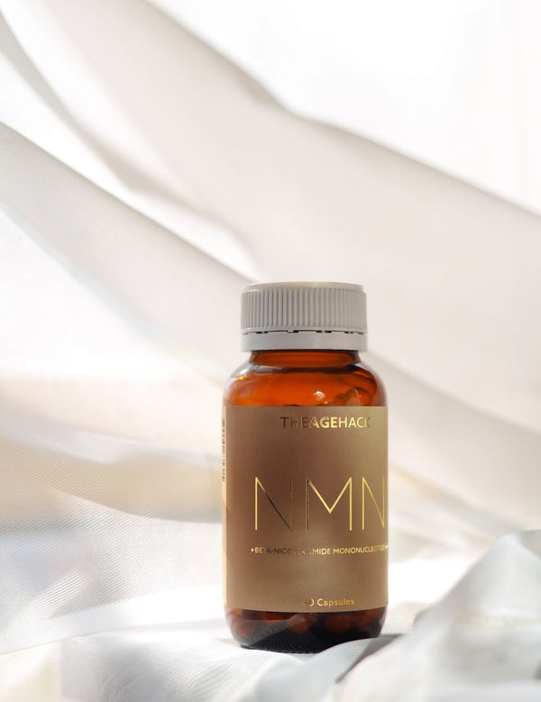 The Age Hack NMN bottle styled on soft white fabric