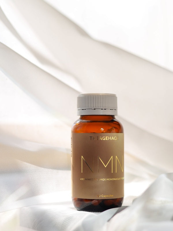 The Age Hack NMN bottle styled on soft white fabric