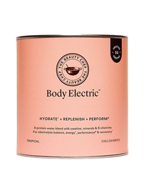 Peach-orange cylindrical The Beauty Chef Body Electric Tropical canister with thin metal rims, a black circular brand emblem above the product name and a small black creatine badge near the top edge.
