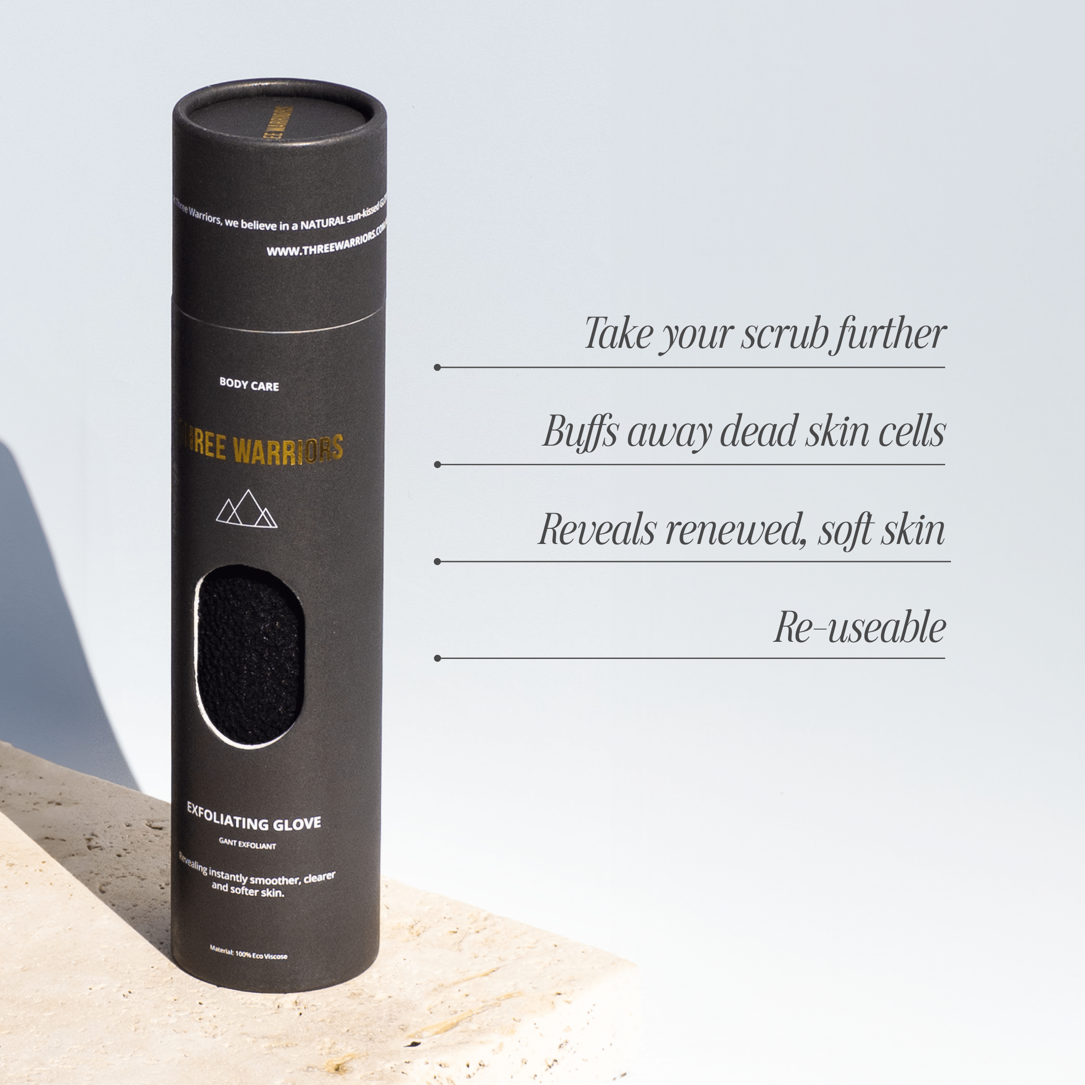 Tall black cylindrical packaging for the Three Warriors Exfoliating Glove, with a window showing its textured surface and text about exfoliation and reuse.