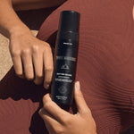 Self Tan Mousse held against bronzed skin