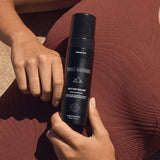 Self Tan Mousse held against bronzed skin