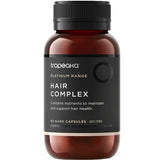 A brown bottle labeled Tropeaka Hair Complex 60 Caps with a black lid. The label notes it provides nutrients to support and maintain hair health, and contains 60 hard capsules by Tropeaka.