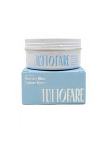 A white jar labeled Tuttofare Roman Blue Tallow Balm 70g, made with grass-fed beef tallow, sits atop a light blue box featuring large white "TUTTO FARE" lettering on the front.