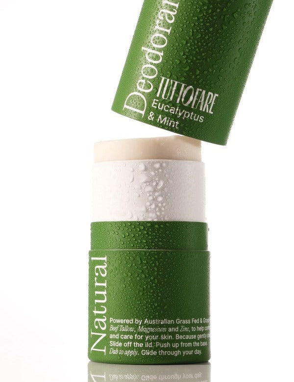 A green deodorant stick with a matching cap leaning against it on a white background. The cap is labeled 'Deodorant TUTTOFARE Eucalyptus & Mint' and the stick container is labeled 'Natural'.