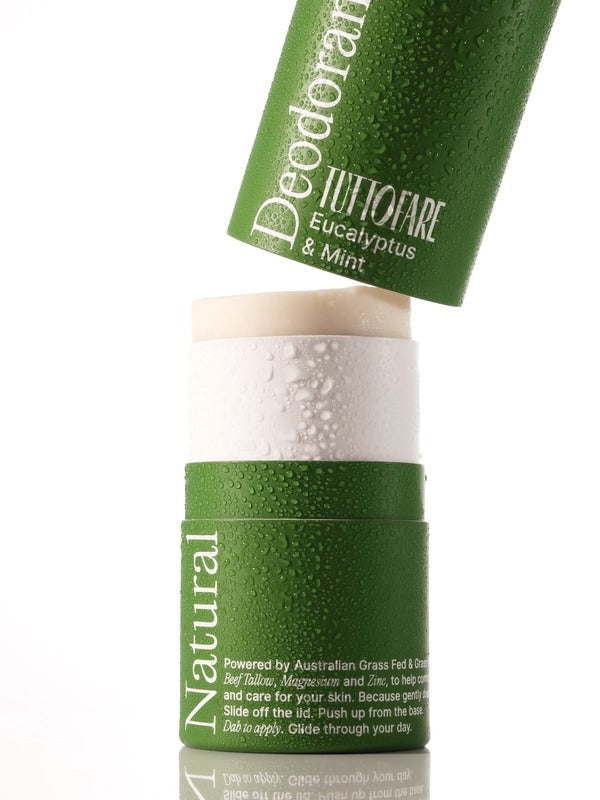 A green deodorant stick with a matching cap leaning against it on a white background. The cap is labeled 'Deodorant TUTTOFARE Eucalyptus & Mint' and the stick container is labeled 'Natural'.