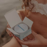 Hand holding an open tin of Tuttofare Roman Blue Tallow Balm