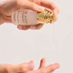 Hand holding a bottle of The Jojoba Company Ultimate Serum