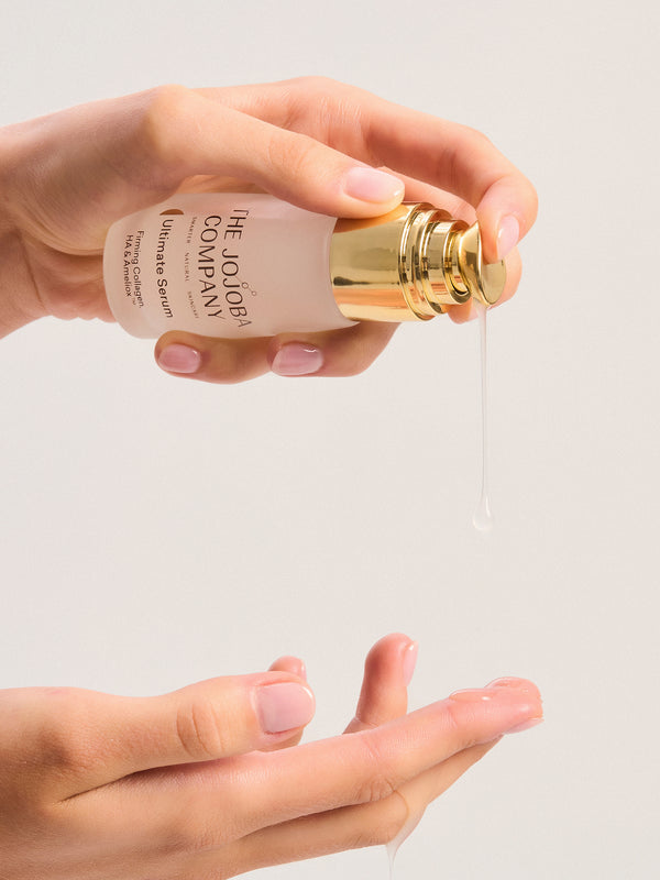 Hand holding a bottle of The Jojoba Company Ultimate Serum