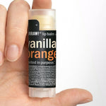 Hand holding Hurraw! Vanilla & Orange Lip Balm 4.8g