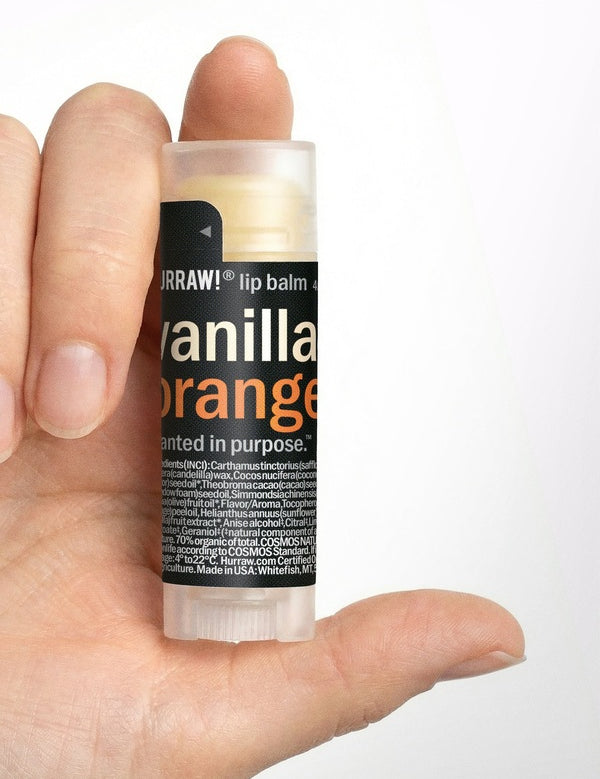 Hand holding Hurraw! Vanilla & Orange Lip Balm 4.8g