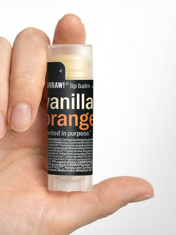 Hand holding Hurraw! Vanilla & Orange Lip Balm 4.8g