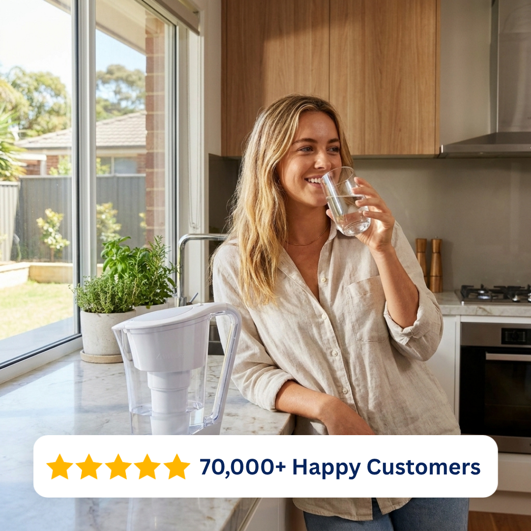 Woman drinking filtered water beside the Waters Co AceBio+ water filter jug