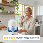 Woman drinking water beside the grey Waters Co BIO 400 MAX benchtop water filter