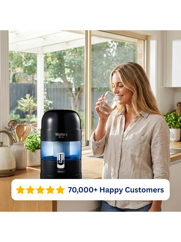 Woman drinking water beside the black Waters Co BIO 500 benchtop water filter