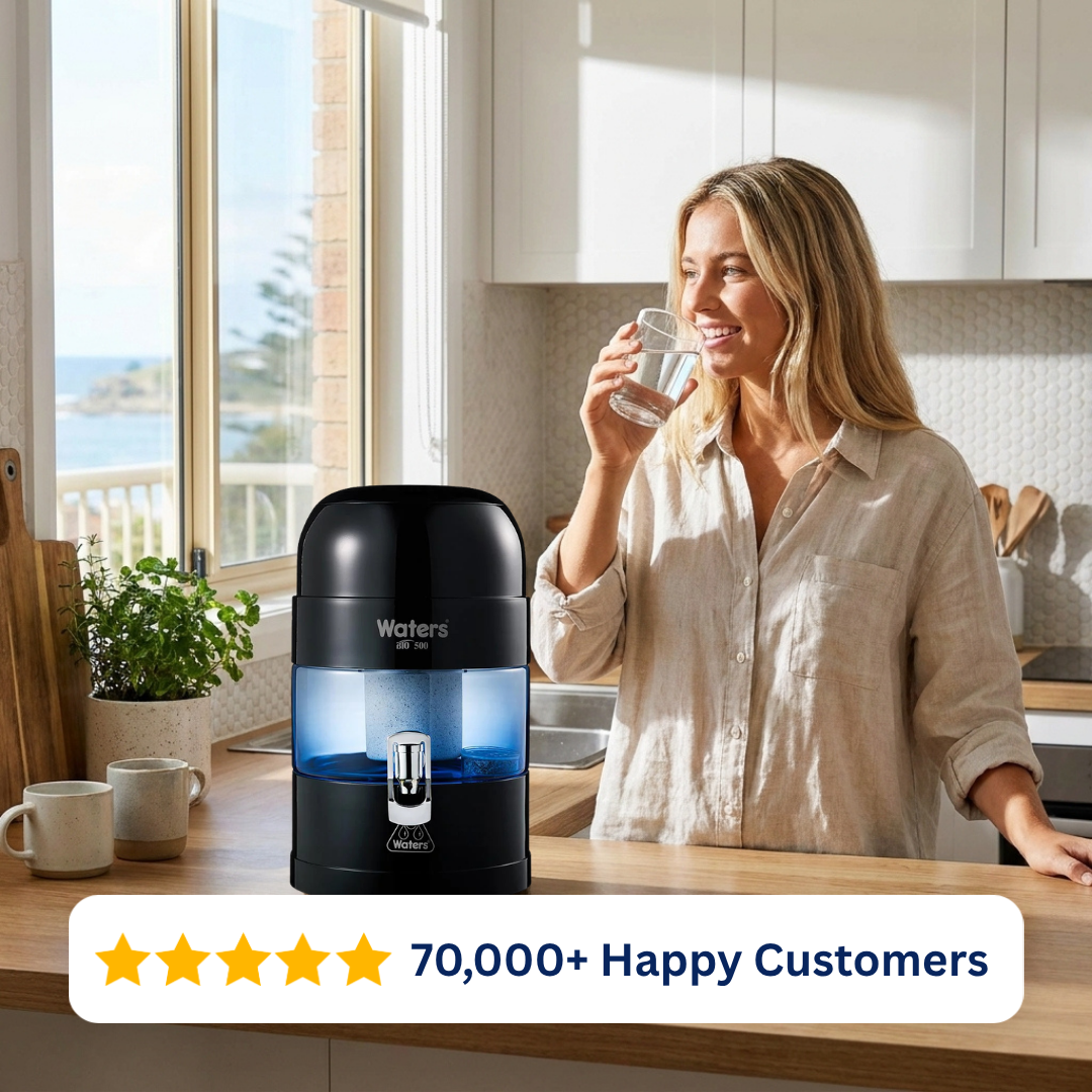 Woman drinking water beside the black Waters Co BIO 500 MAX benchtop water filter
