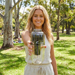Woman holding the black Waters Co Waterman portable filter outdoors