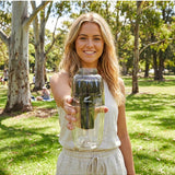 Woman holding the black Waters Co Waterman portable filter outdoors