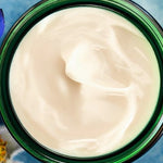Open green glass jar of Weleda Blue Gentian and Edelweiss Contouring Night Cream viewed from above, showing the rich white cream texture.