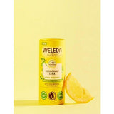 Deodorant Stick Citrus-Bergamot next to a slice of lemon, against yellow background.