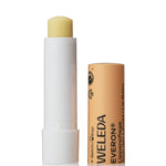 Open Weleda Everon Lip Balm stick standing beside its brown printed cap on a clean white background.