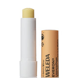 Open Weleda Everon Lip Balm stick standing beside its brown printed cap on a clean white background.