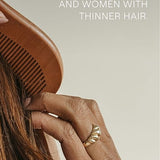 Hands drawing a wooden comb through long brown hair beneath text noting suitability for men and women with thinner hair.
