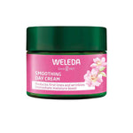 A jar of Weleda Smoothing Day Cream - Wild Rose & White Tea with a green lid and pink, floral label that highlights Age Protect Complex for reducing first lines and wrinkles and giving an instant moisture boost.