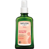 A green 100ml bottle of Weleda Stretch Mark Massage Oil with a pump; its label shows a pregnant silhouette and highlights benefits for all skin types—improving elasticity and reducing the look of stretch marks.