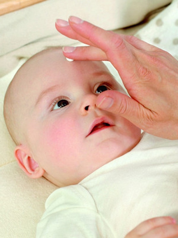 Baby with Weleda White Mallow cream being gently applied