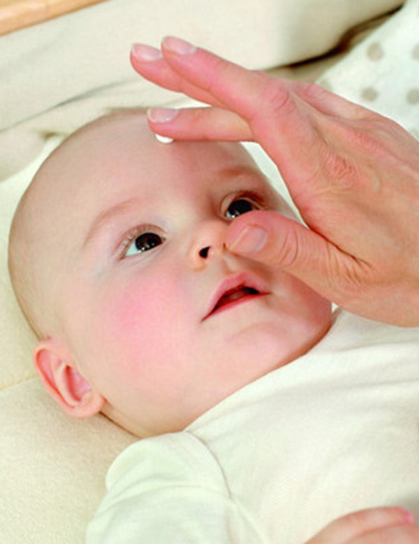 Applying Weleda White Mallow Face Cream to baby's skin