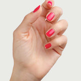 A hand with nails painted in vibrant fuchsia pink Sienna Byron Bay Nail Polish - Wonder is shown against a plain light background, with slightly curled fingers and a neatly manicured, toxin-free finish.