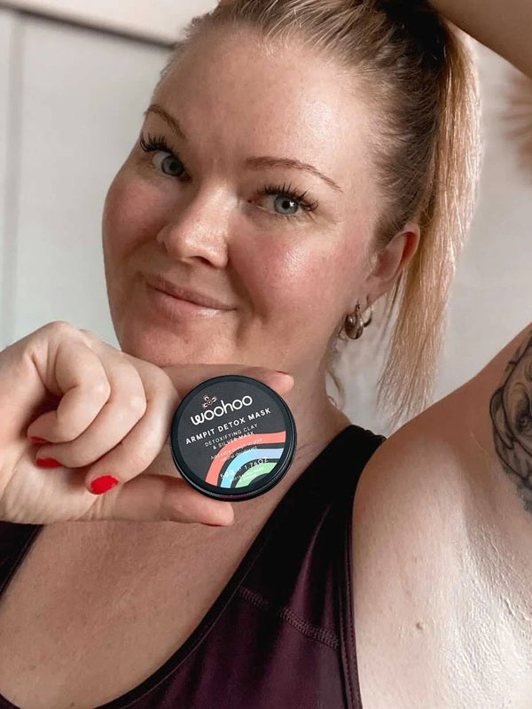 Woman holding WooHoo Armpit Detox Mask beside her underarm