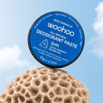 WooHoo Drift deodorant paste balanced above coral against a blue sky
