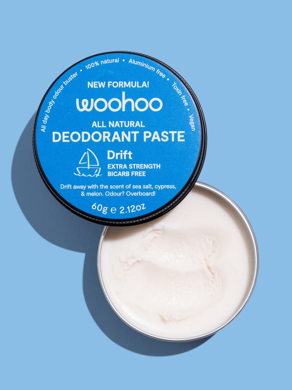 Open WooHoo Drift deodorant paste showing its creamy texture on a blue background