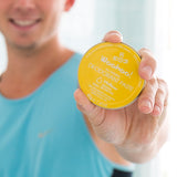 Man holding WooHoo Mellow unscented deodorant paste toward the camera