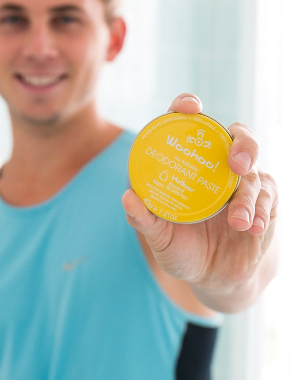 Man holding WooHoo Mellow unscented deodorant paste toward the camera