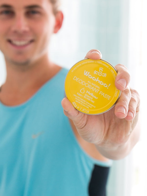 Man holding WooHoo Mellow unscented deodorant paste toward the camera