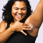 Woman applying WooHoo Pop deodorant paste to her underarm