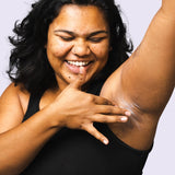 Woman applying WooHoo Pop deodorant paste to her underarm