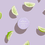 WooHoo Pop deodorant paste styled with fresh lime wedges on a purple background