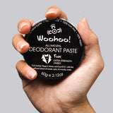 WooHoo Tux deodorant paste held in a hand against a grey background
