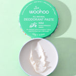 Open WooHoo Wild deodorant paste showing its creamy texture on a green background