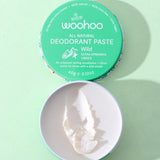 Open WooHoo Wild deodorant paste showing its creamy texture on a green background
