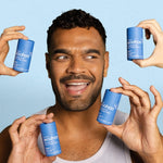 Smiling man surrounded by WooHoo Drift natural deodorant sticks