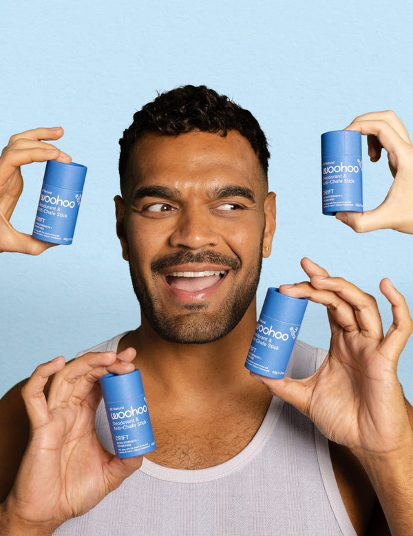 Smiling man surrounded by WooHoo Drift natural deodorant sticks