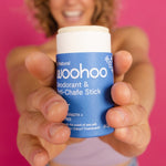 Woman holding WooHoo Drift deodorant stick toward the camera