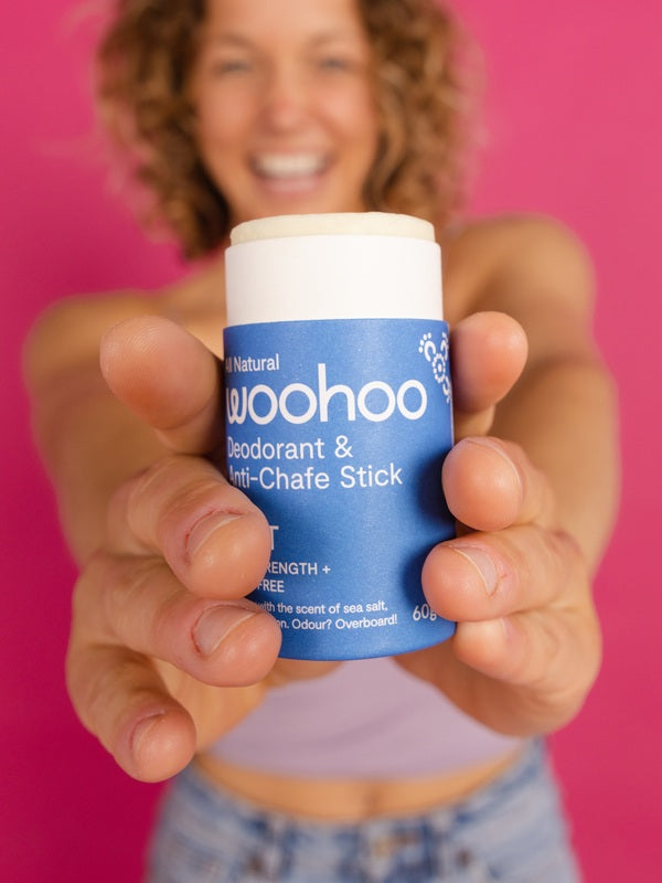Woman holding WooHoo Drift deodorant stick toward the camera
